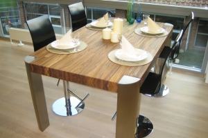 Moderner und eleganter Esstisch mit Edelstahl Beinen aus einer Zebrano Massivholzplatte